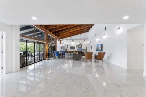 a view of a big room with dining area a chandelier and fireplace