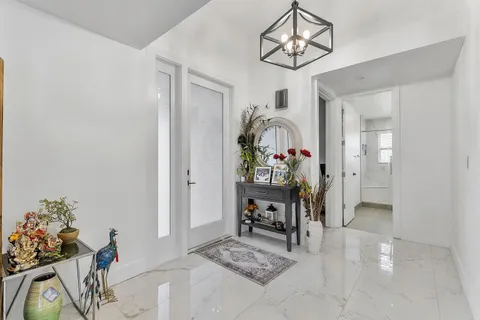 a view of a livingroom with furniture and a chandelier fan