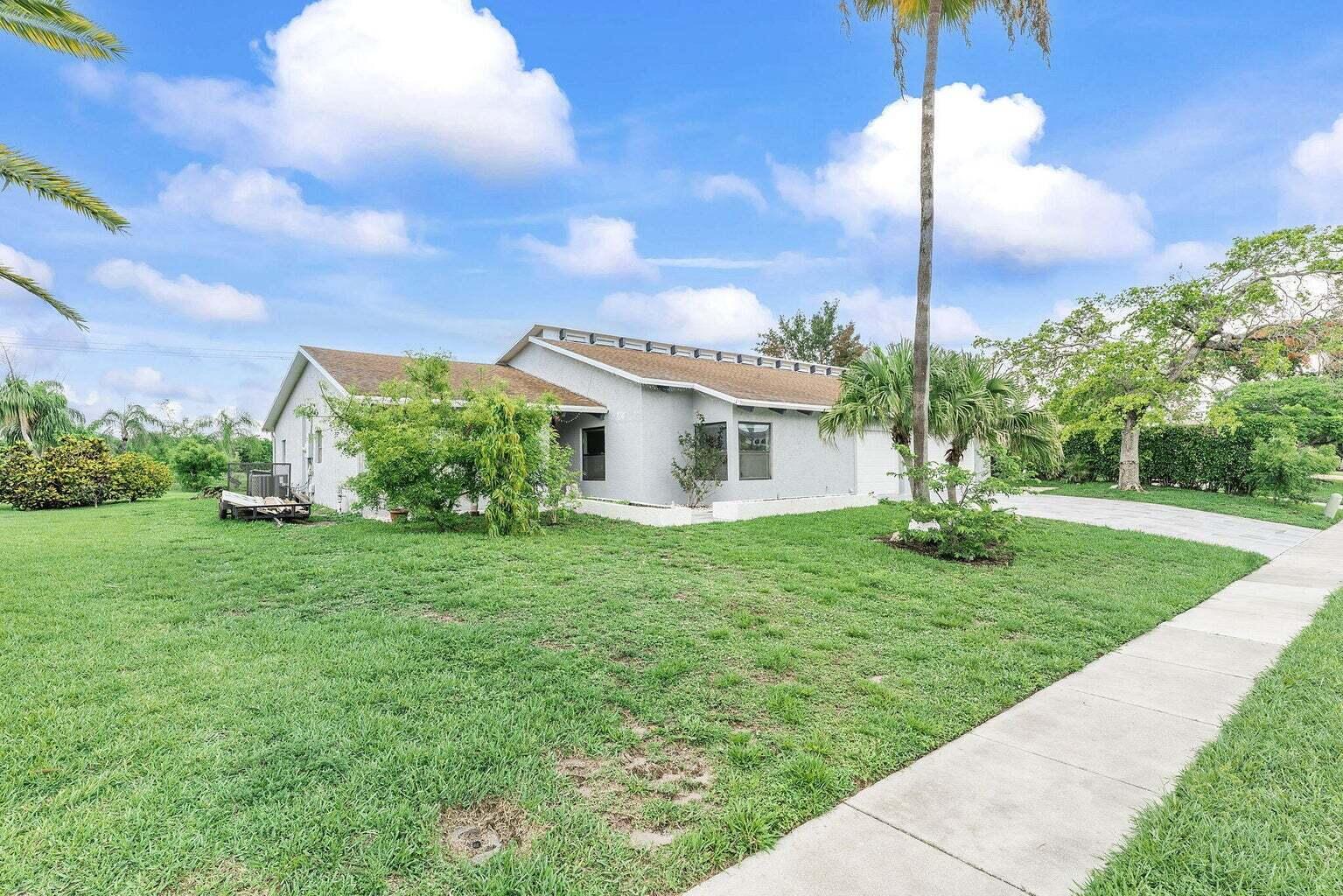 6031 Northwest 4th Avenue Boca Raton, FL 33487 - Photo 2 of 36 a front view of a house with garden