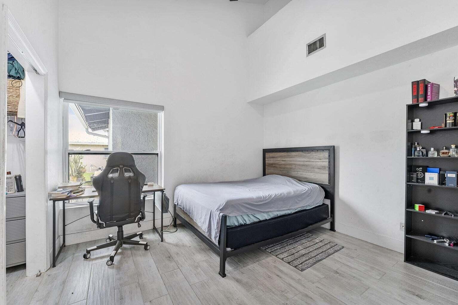 6031 Northwest 4th Avenue Boca Raton, FL 33487 - Photo 22 of 36 a bedroom with a bed and a chair