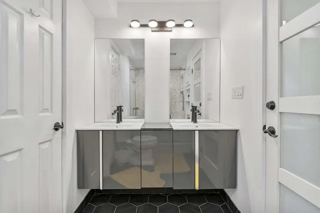 a bathroom with a double vanity sink a mirror and a shower