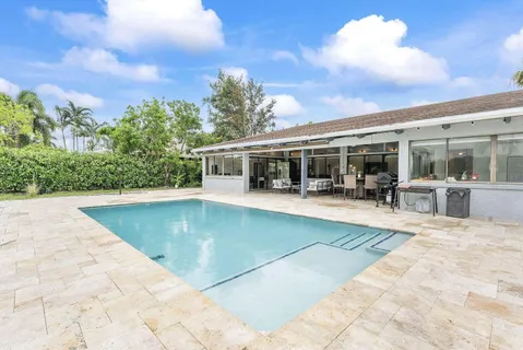 a view of house with swimming pool and sitting area