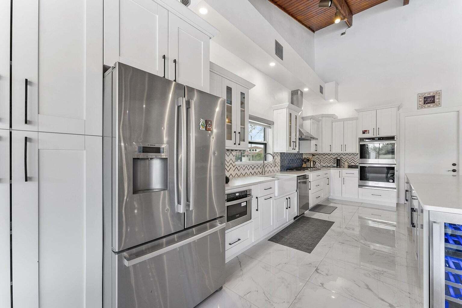 6031 Northwest 4th Avenue Boca Raton, FL 33487 - Photo 6 of 36 a kitchen with stainless steel appliances a refrigerator sink and microwave