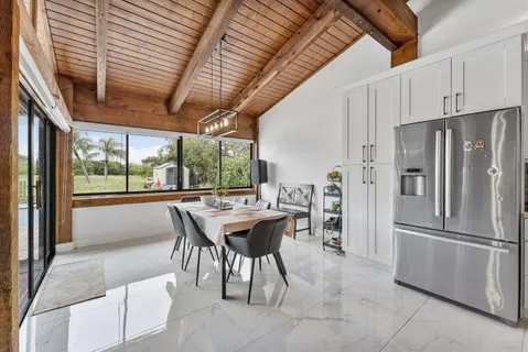 a kitchen with stainless steel appliances kitchen island granite countertop furniture and a refrigerator