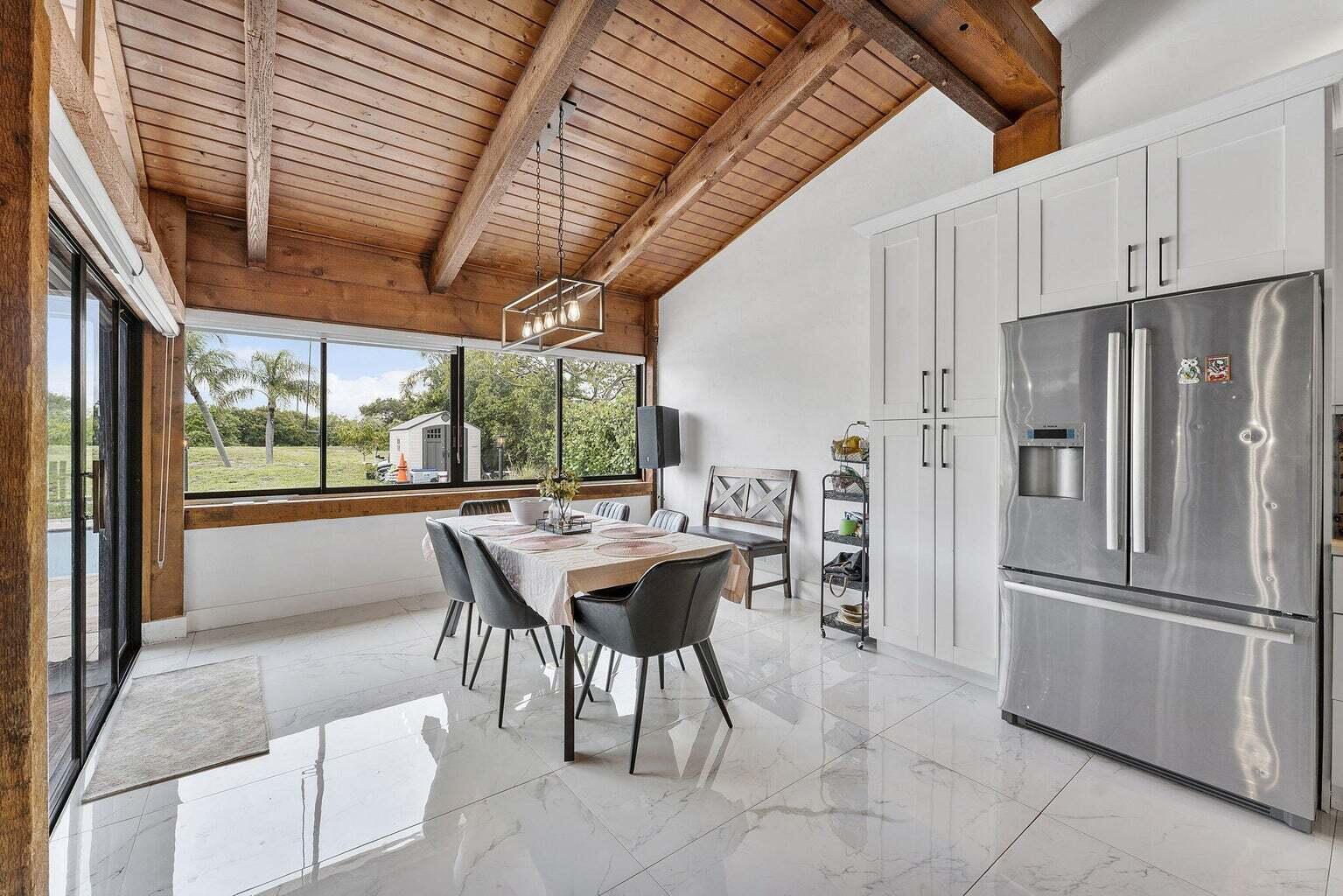 6031 Northwest 4th Avenue Boca Raton, FL 33487 - Photo 9 of 36 a kitchen with stainless steel appliances kitchen island granite countertop furniture and a refrigerator
