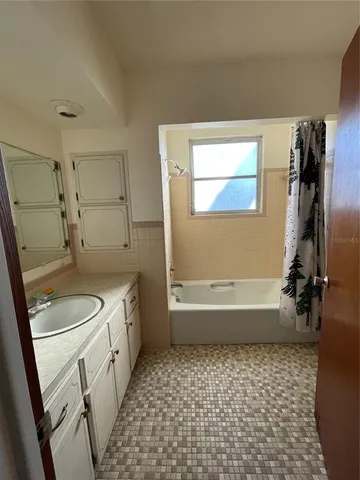 a bathroom with a granite countertop sink a toilet and bathtub