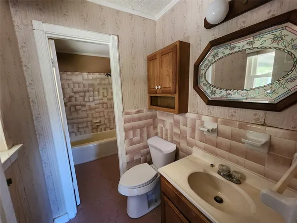a bathroom with a toilet sink and mirror