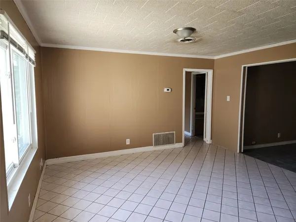 a view of an empty room with window and closet area