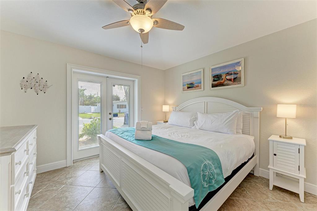 308 58th Street, Unit A Holmes Beach, FL 34217 - Photo 15 of 41 a bedroom with a large bed and a chandelier