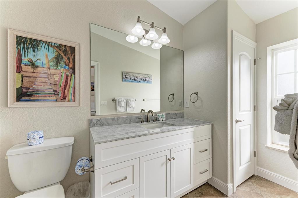 308 58th Street, Unit A Holmes Beach, FL 34217 - Photo 18 of 41 a bathroom with a granite countertop sink mirror vanity and a toilet
