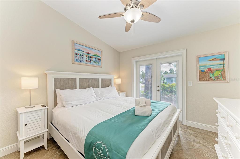 308 58th Street, Unit A Holmes Beach, FL 34217 - Photo 20 of 41 a bedroom with a large bed and a chandelier
