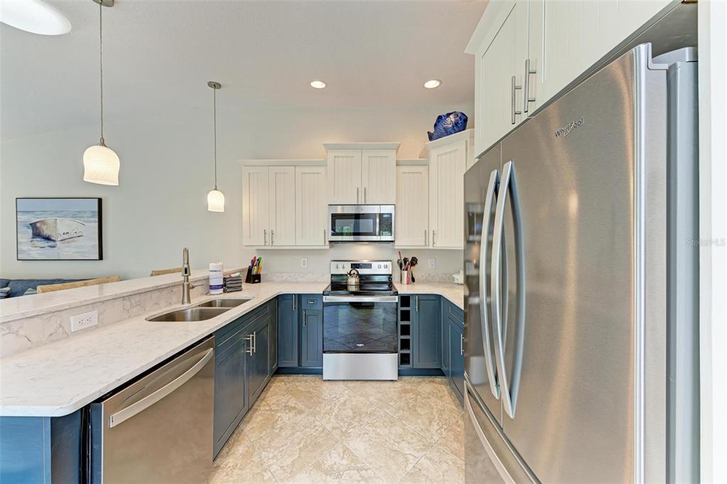 308 58th Street, Unit A Holmes Beach, FL 34217 - Photo 6 of 41 a kitchen with stainless steel appliances granite countertop a refrigerator a sink a stove a microwave and island