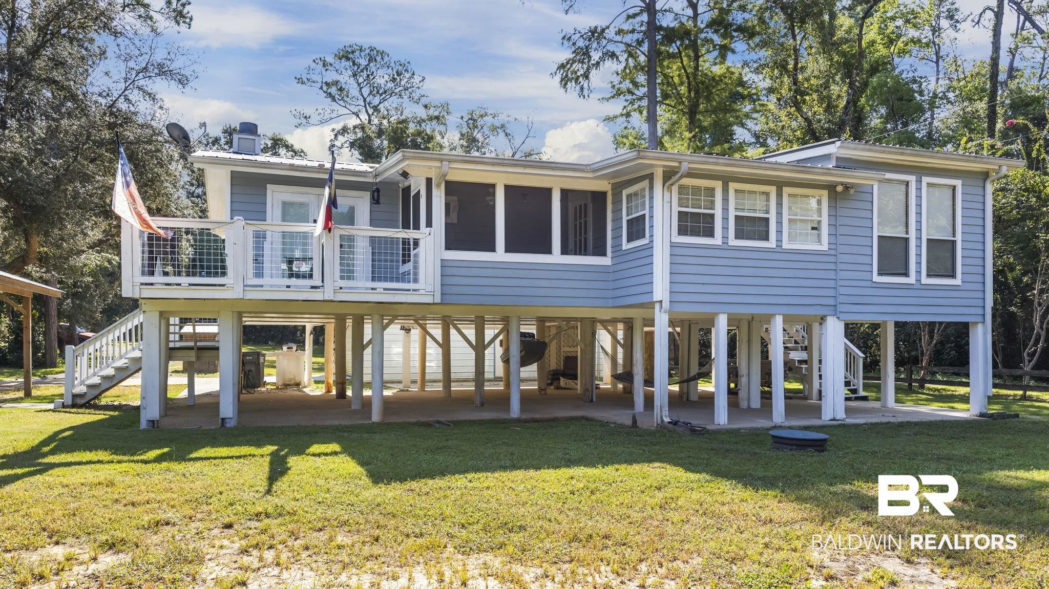 12855 Woodhaven Dairy Road West Silverhill, AL 36576 - Photo 2 of 27 Rear view of house featuring stairs, a deck, a patio area, and a yard