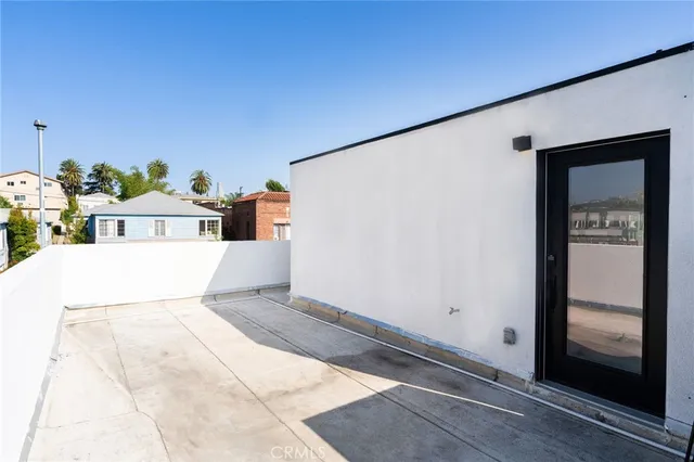 a white house with potted plants in front of door