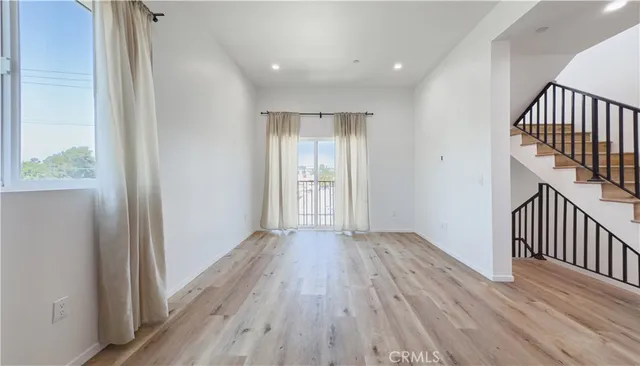 a view of a hallway with wooden floor and staircase