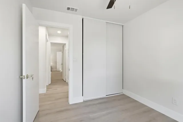 an empty room with wooden floor and mirror