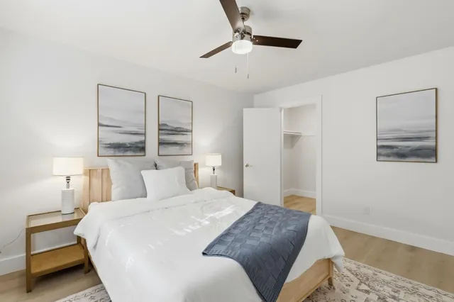 a bedroom with a bed and a lamp with the wooden floor