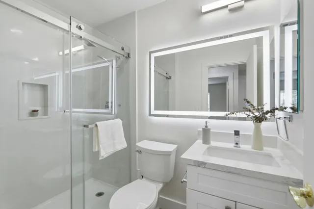 a bathroom with a sink vanity mirror and toilet