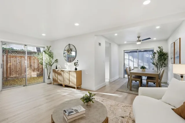 a living room with furniture a dining table and a large window