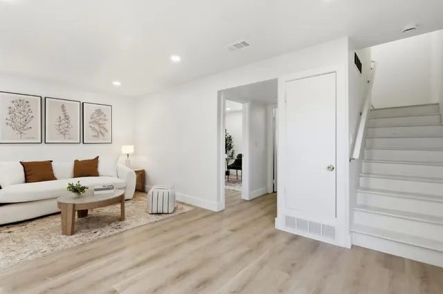 a living room with furniture and wooden floor