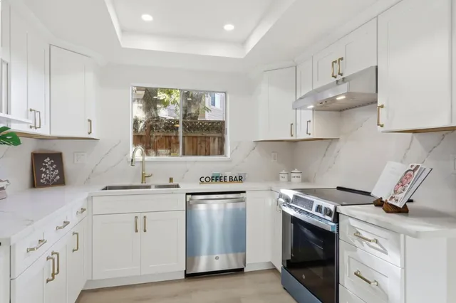 a kitchen with white cabinets and appliances