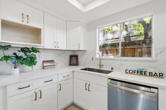 a kitchen with stainless steel appliances white cabinets and a window