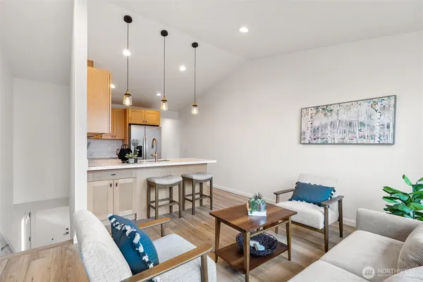 a living room with furniture a rug and white walls