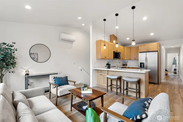 a living room with furniture kitchen view and a chandelier