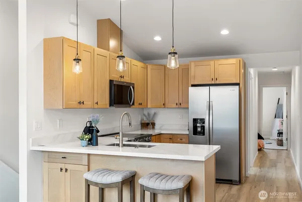 a kitchen with a refrigerator a sink and cabinets