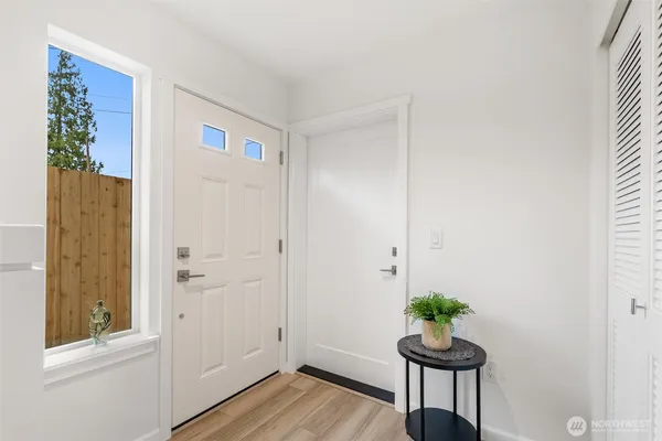 a view of a hallway with wooden floor and a potted plant
