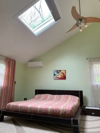a bed sitting in a bedroom next to a window