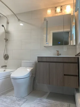 a bathroom with a toilet a sink and mirror