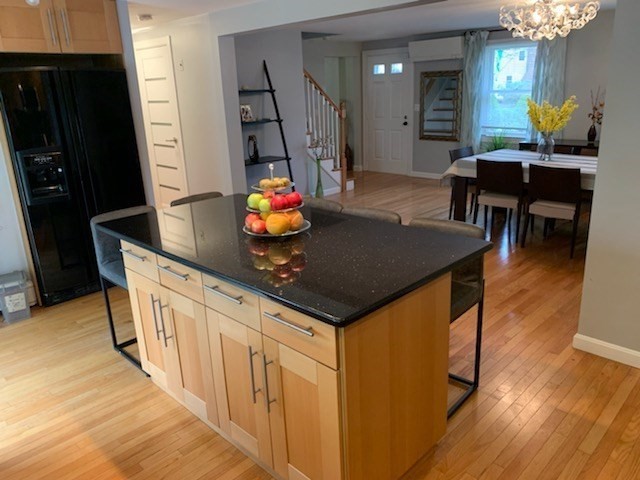 31 Hunnewell Street, Unit 31 Needham, MA 02494 - Photo 4 of 21 a kitchen with stainless steel appliances granite countertop a sink dishwasher a refrigerator and a dining table with wooden floor