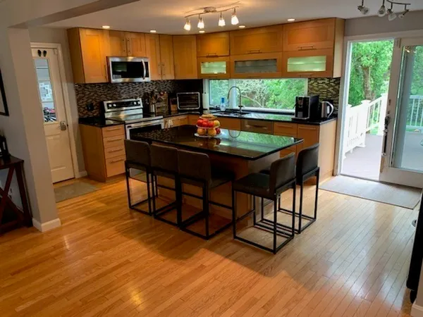 a room with stainless steel appliances wooden floor large windows and wooden floor