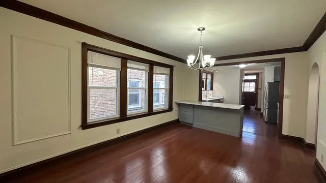 a view of a room with chandelier and wooden floors