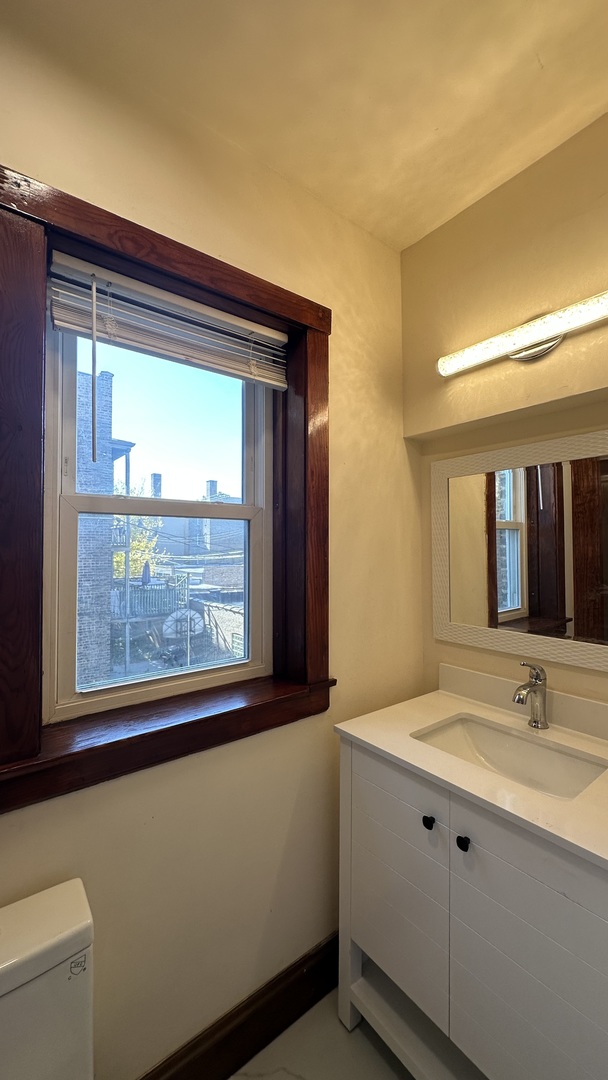 5530 North Artesian Avenue, Unit 1 Chicago, IL 60625 - Photo 15 of 16 a bathroom with a sink and a large mirror