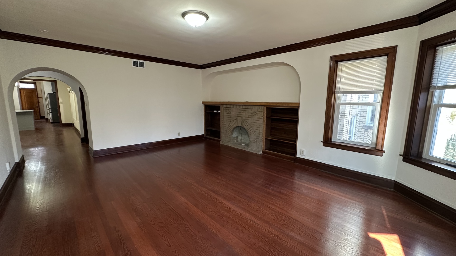5530 North Artesian Avenue, Unit 1 Chicago, IL 60625 - Photo 3 of 16 a view of empty room with wooden floor and fireplace