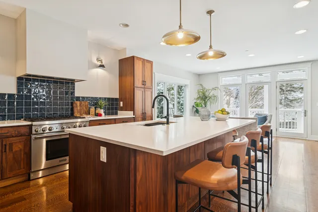 a kitchen with stainless steel appliances granite countertop a sink a stove and a table