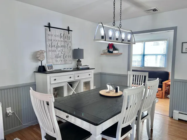 a view of a dining room with furniture a chandelier and wooden floor