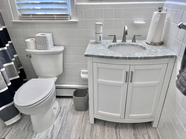 a bathroom with a granite countertop toilet sink and mirror