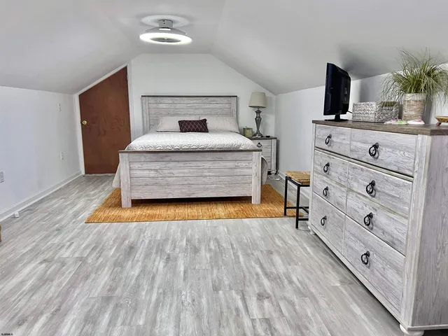 a room with a wooden floor and chandelier