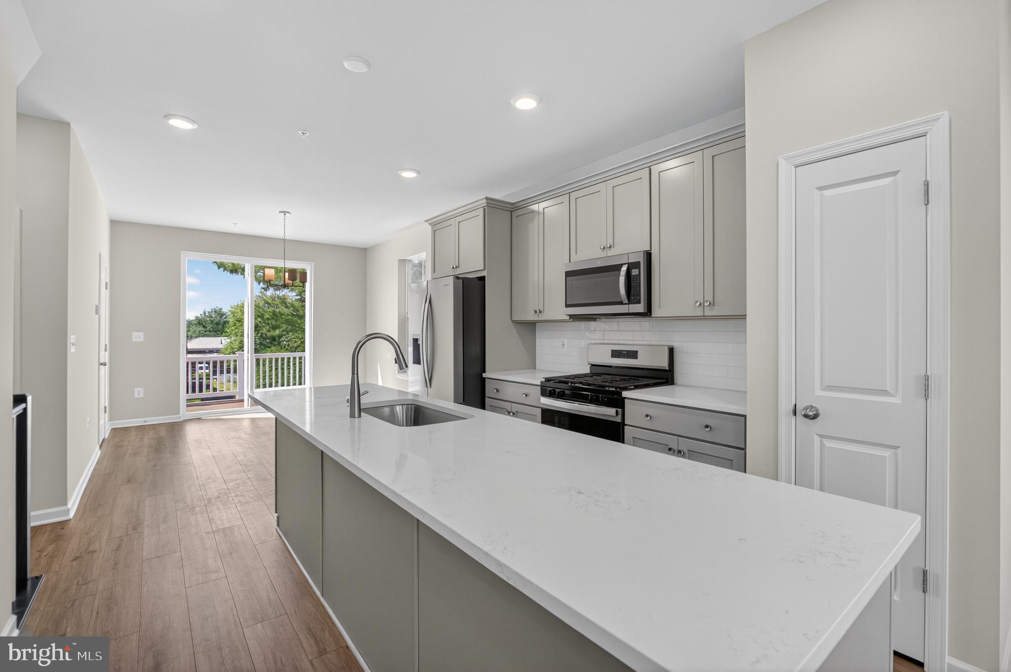 10046 Harper Vale Road Montgomery Village, MD 20886 - Photo 2 of 15 a kitchen with sink a stove and refrigerator