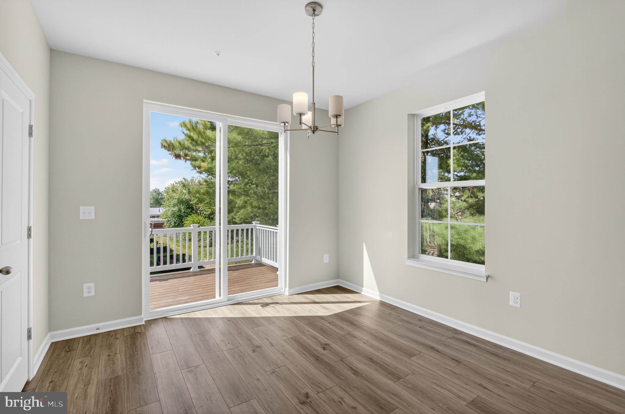 10046 Harper Vale Road Montgomery Village, MD 20886 - Photo 6 of 15 a view of an empty room with wooden floor and a window