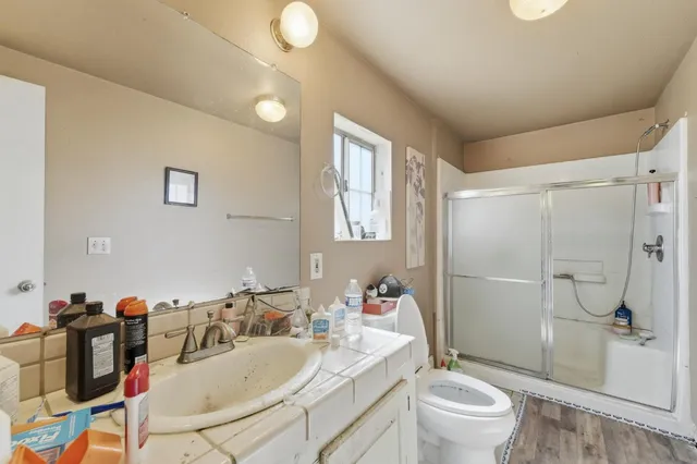 a bathroom with a sink toilet vanity and shower