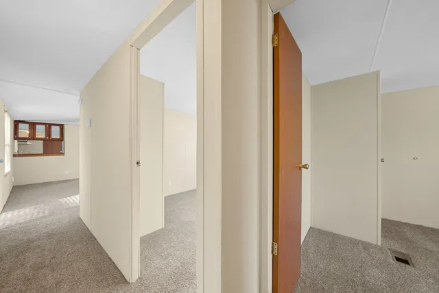 a view of a hallway with wooden floor and closet
