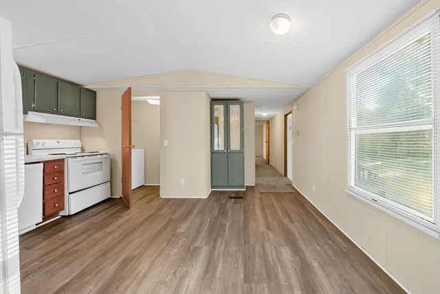 a view of a kitchen with a sink and dishwasher with wooden floor