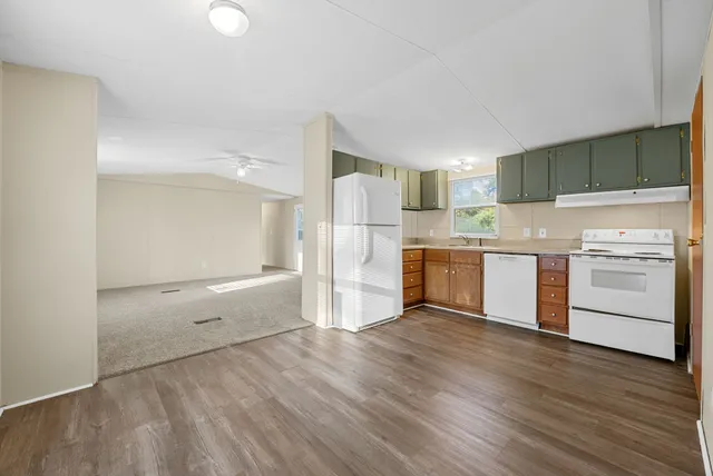 a kitchen with a refrigerator and a stove top oven