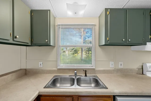 a kitchen with a sink cabinets and a window