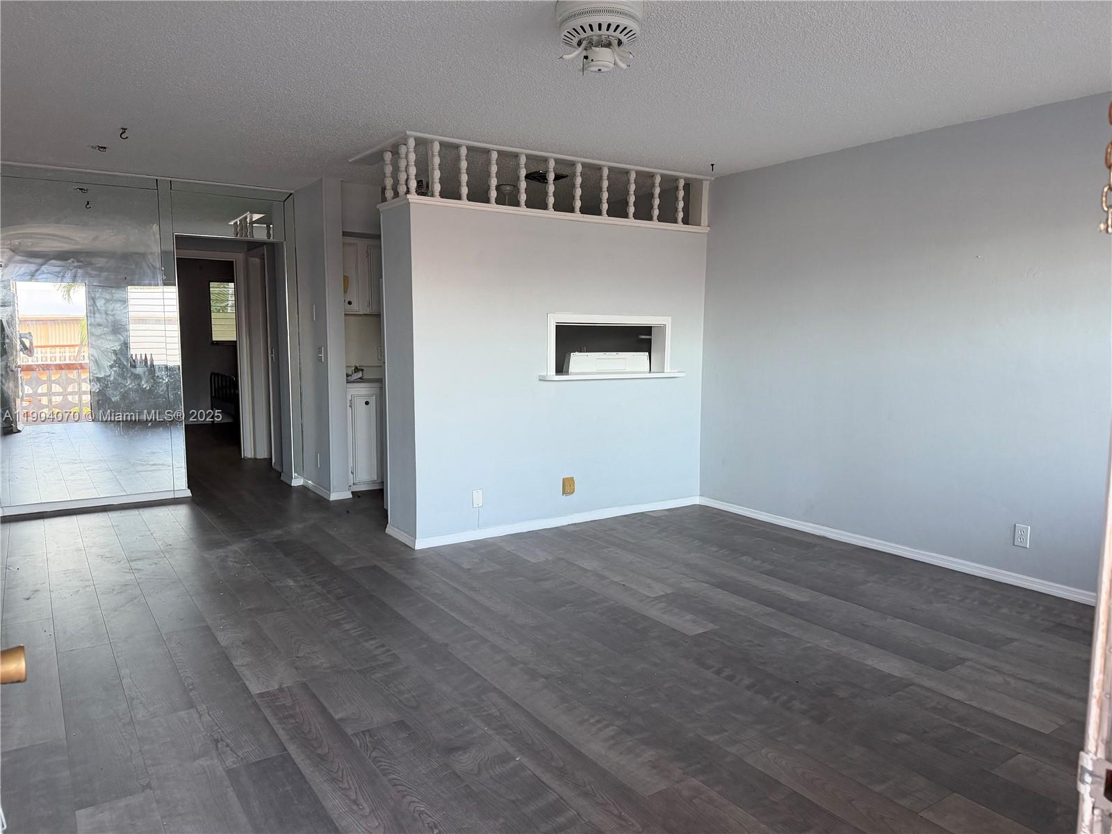 815 Southwest 10th Terrace, Unit 15V Hallandale Beach, FL 33009 - Photo 5 of 6 an empty room with wooden floor and windows