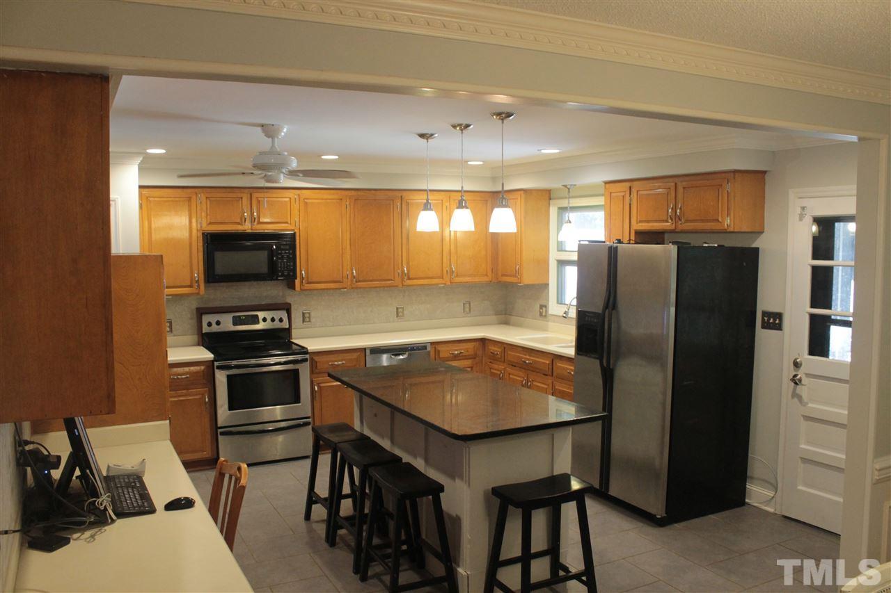 9621 Rock Creek Road Raleigh, NC 27613 - Photo 3 of 15 a kitchen with stainless steel appliances granite countertop a refrigerator a sink and a stove